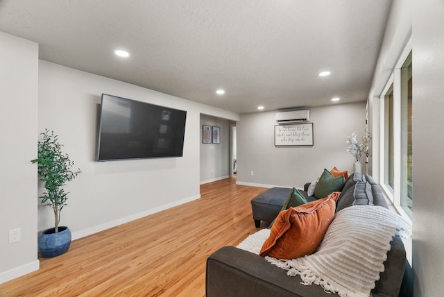 living area with recessed lighting, a wall unit AC, baseboards, and wood finished floors