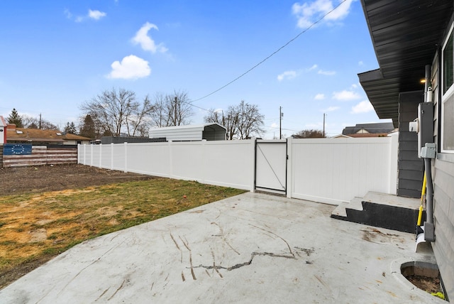 view of yard featuring entry steps, a gate, fence, and a patio