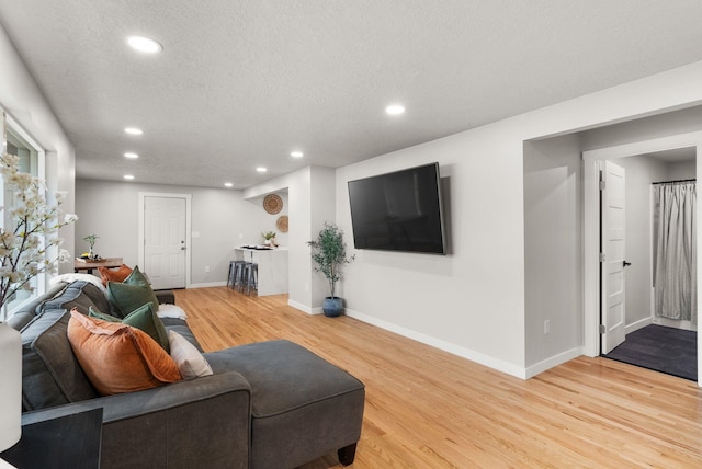 living room with light wood finished floors, baseboards, and recessed lighting