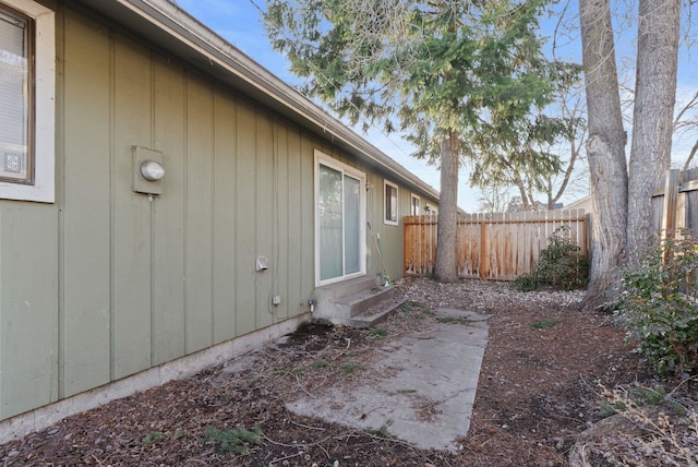 view of side of property featuring entry steps and fence