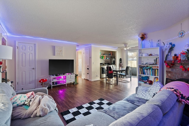 living area with a ceiling fan, a textured ceiling, and wood finished floors