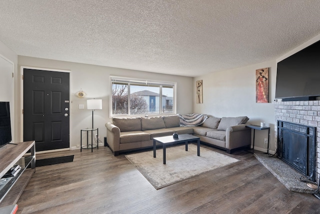 living area featuring a textured ceiling, a fireplace, and wood finished floors