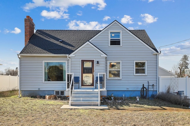 bungalow-style home with a front lawn, roof with shingles, and fence