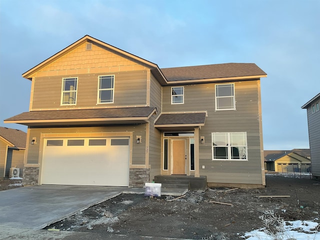 view of front of property featuring a garage, roof with shingles, and driveway