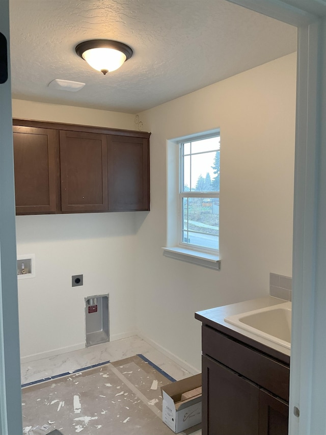 clothes washing area with hookup for a washing machine, cabinet space, hookup for an electric dryer, a textured ceiling, and baseboards