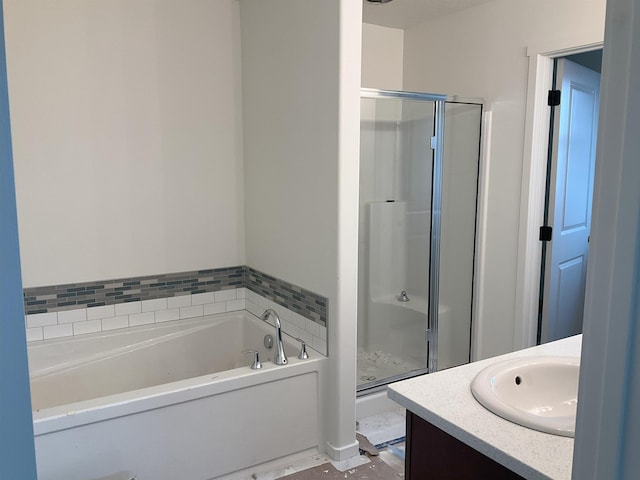 full bath featuring a stall shower, vanity, and a bath