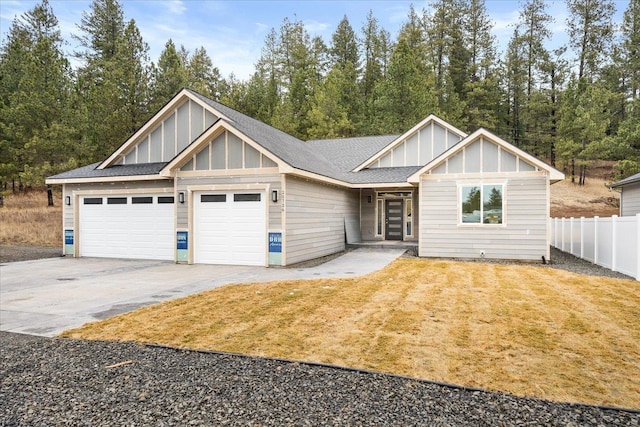 view of front of home with board and batten siding, concrete driveway, fence, and an attached garage