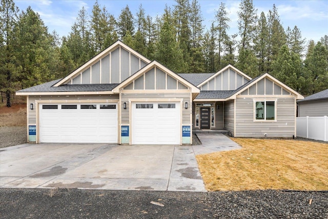 view of front facade with board and batten siding, fence, a garage, driveway, and a front lawn