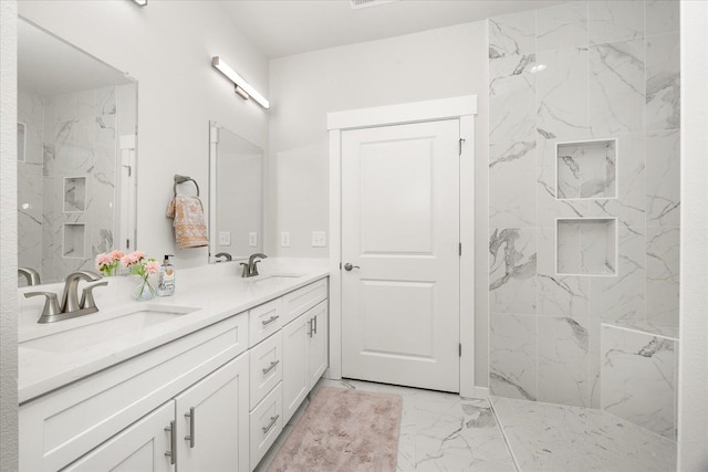 bathroom featuring marble finish floor, a marble finish shower, and a sink