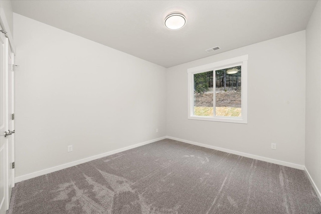 carpeted empty room featuring visible vents and baseboards