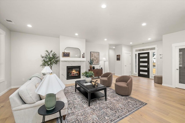 living area with light wood-style floors, recessed lighting, and a fireplace