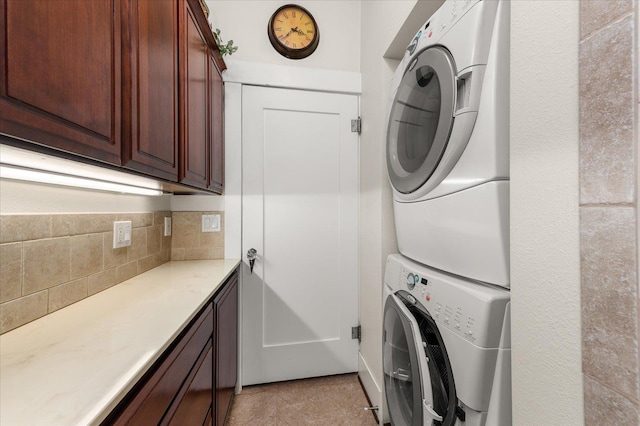 clothes washing area with stacked washer and dryer and cabinet space