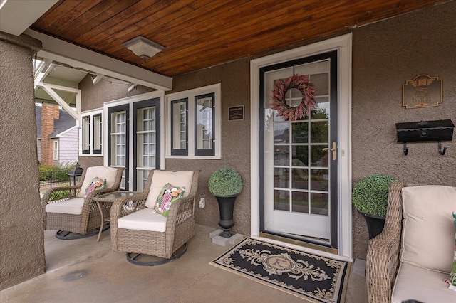 entrance to property featuring covered porch and stucco siding