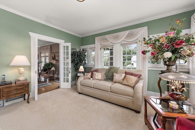 carpeted living area with ornamental molding and french doors