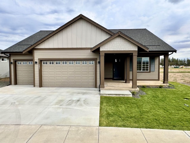 view of front facade with roof with shingles, board and batten siding, a front yard, a garage, and driveway