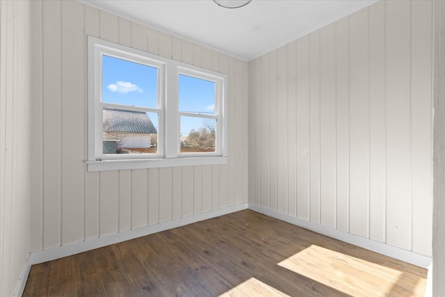 spare room featuring wood finished floors and baseboards