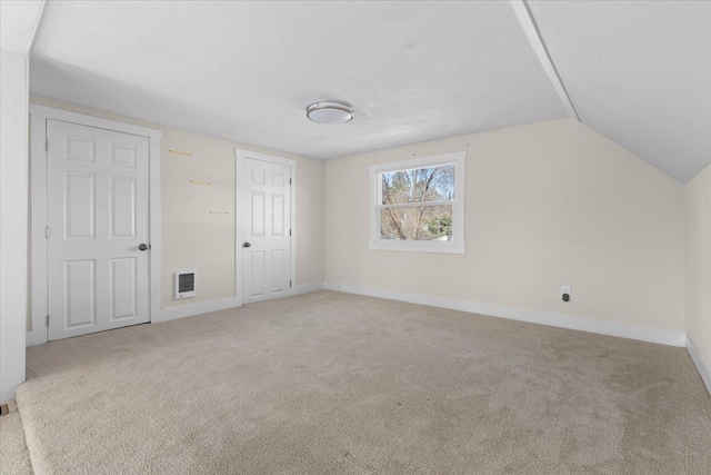 bonus room featuring carpet floors, lofted ceiling, visible vents, and baseboards