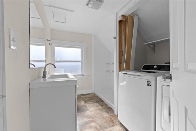 laundry room with laundry area, baseboards, a sink, and washing machine and clothes dryer