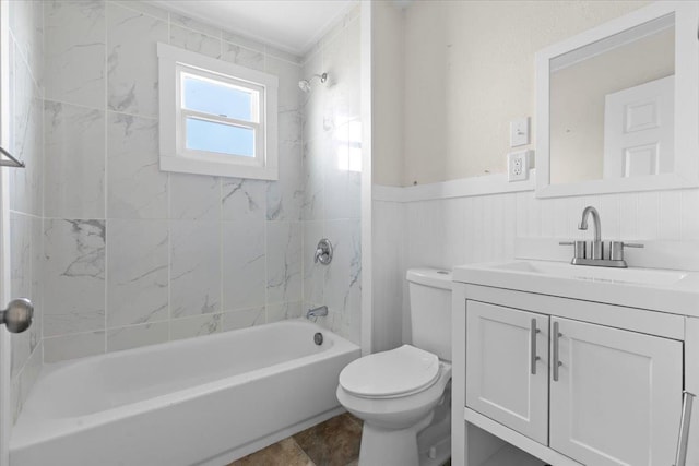 bathroom featuring wainscoting, vanity, toilet, and tub / shower combination