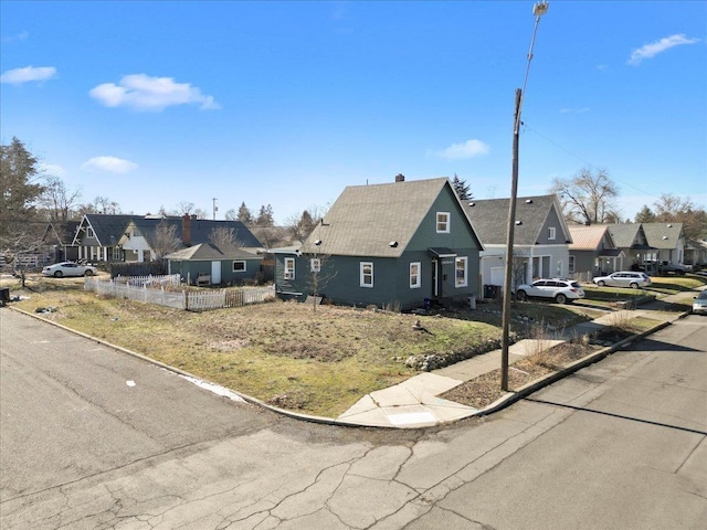 view of front of home featuring a residential view and fence