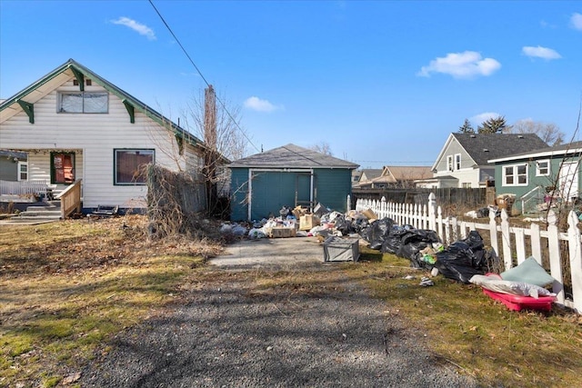 view of front of property featuring fence and an outdoor structure