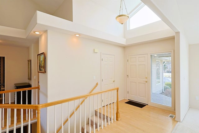 entrance foyer with baseboards, visible vents, a high ceiling, light wood-style floors, and recessed lighting