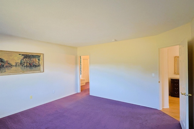 carpeted empty room featuring baseboards