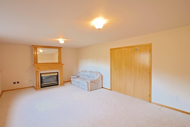 unfurnished room with a large fireplace, light carpet, and baseboards