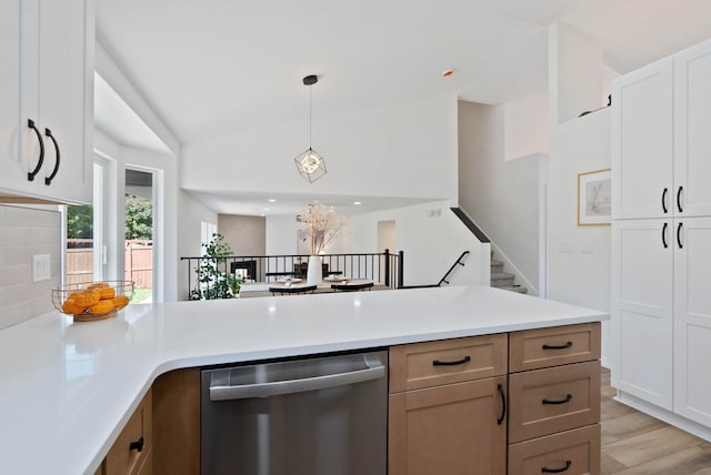 kitchen with light wood-type flooring, pendant lighting, light countertops, lofted ceiling, and dishwasher