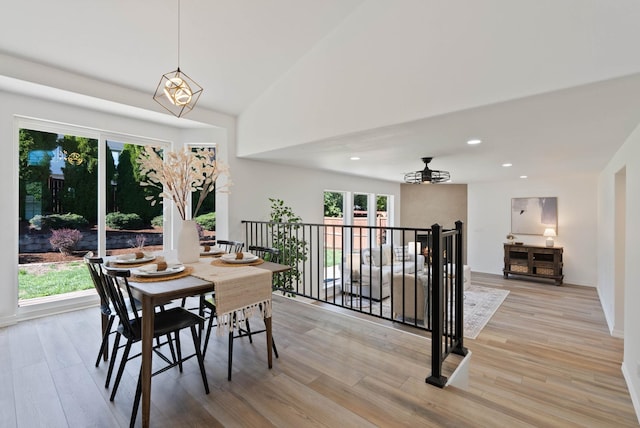 dining area with a chandelier, recessed lighting, light wood-style floors, and vaulted ceiling