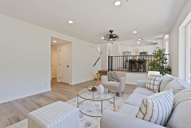 living area with recessed lighting, baseboards, stairs, and light wood finished floors