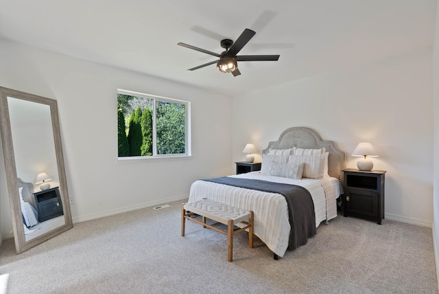 carpeted bedroom with baseboards, ceiling fan, and a fireplace