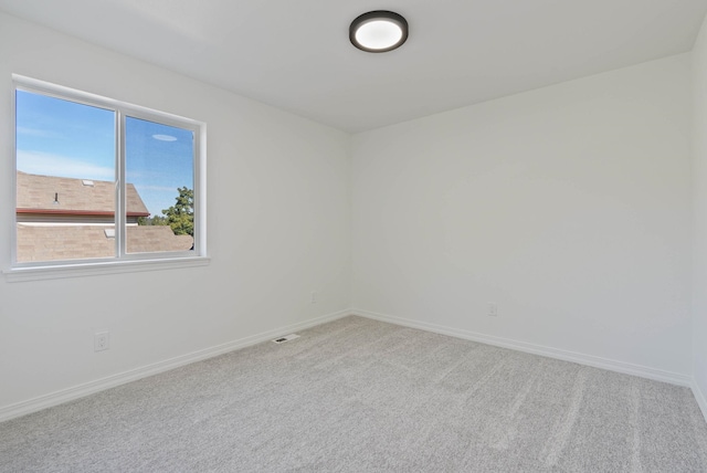 carpeted empty room with visible vents and baseboards