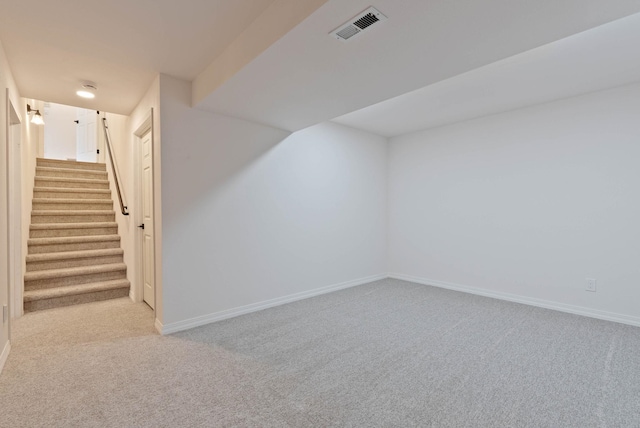 additional living space featuring light carpet, visible vents, stairway, and baseboards