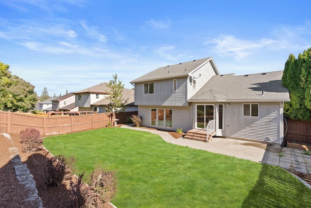 rear view of house featuring a shingled roof, a lawn, a fenced backyard, and a patio area