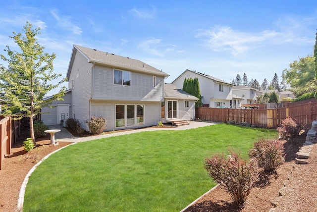 rear view of house featuring a patio area, a lawn, a fenced backyard, and entry steps