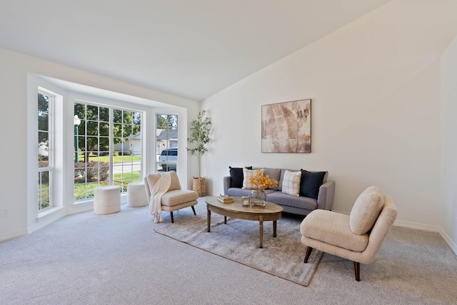 living room featuring vaulted ceiling, carpet, and baseboards