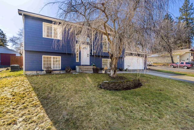 split foyer home with central AC, driveway, a front lawn, and fence