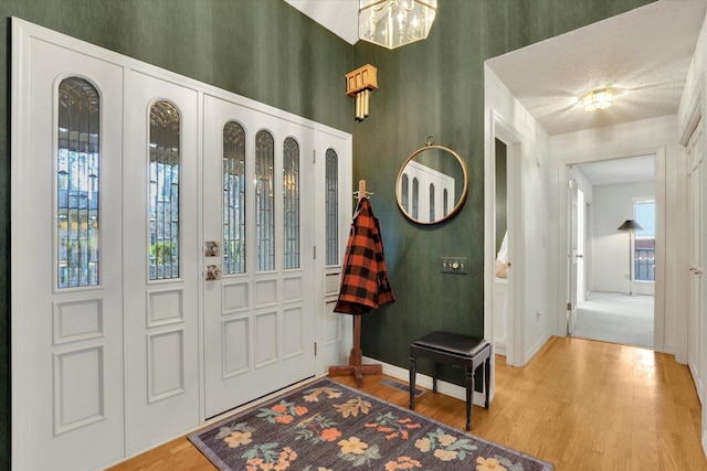 foyer featuring visible vents, baseboards, and wood finished floors