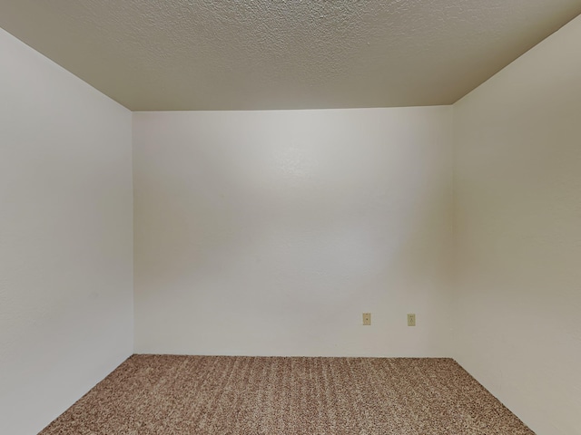 empty room with a textured ceiling and carpet