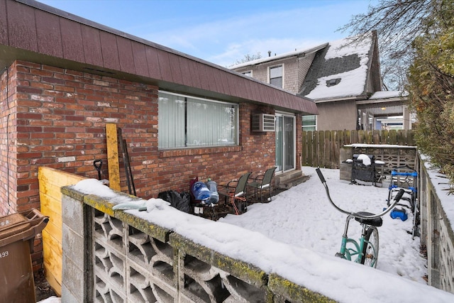 exterior space featuring brick siding and fence