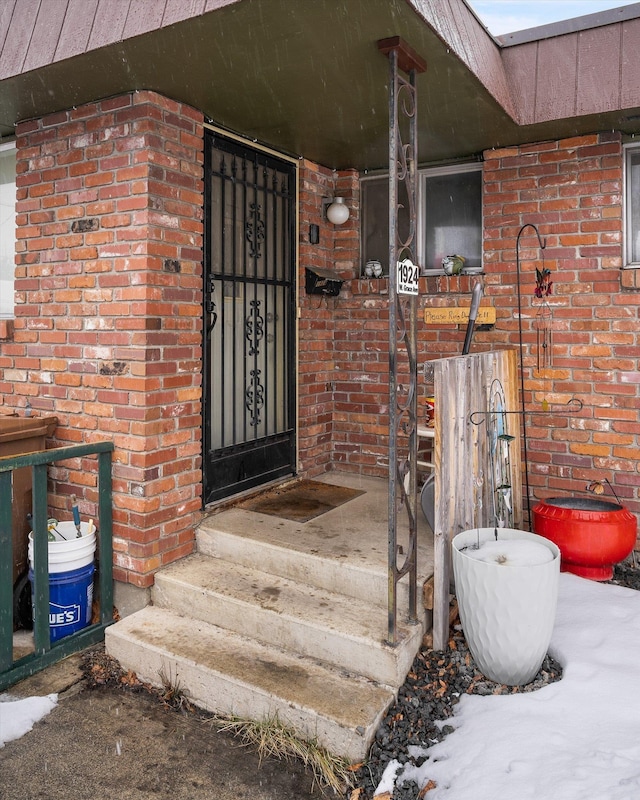 doorway to property featuring brick siding