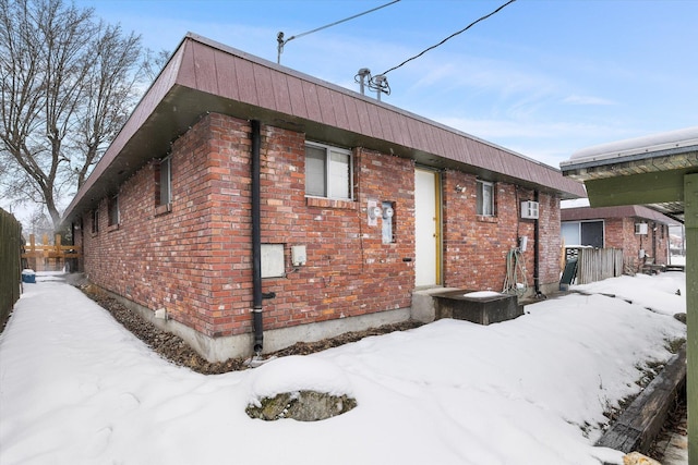 view of snow covered exterior featuring brick siding