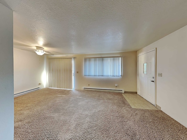 foyer featuring a baseboard heating unit, carpet flooring, and a textured ceiling