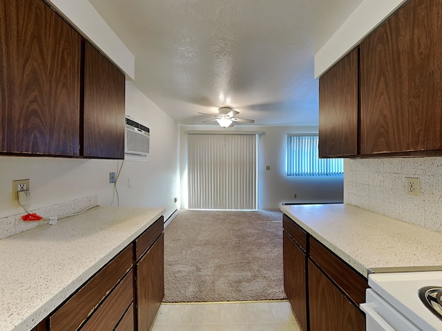 kitchen featuring light carpet, decorative backsplash, a ceiling fan, light countertops, and dark brown cabinets