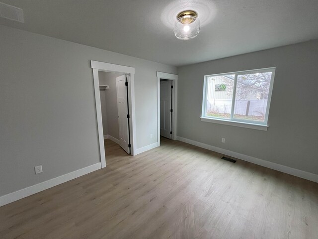 unfurnished bedroom featuring multiple closets and visible vents