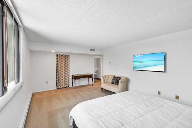 bedroom featuring visible vents, baseboard heating, a textured ceiling, and light colored carpet