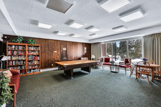 recreation room featuring carpet floors, wood walls, a textured ceiling, and baseboard heating