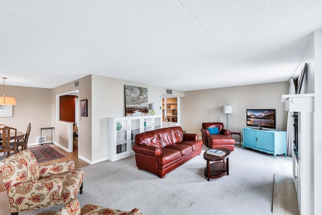 living area with a textured ceiling, carpet floors, and baseboards