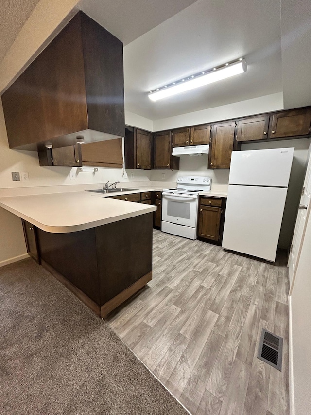 kitchen featuring under cabinet range hood, white appliances, visible vents, dark brown cabinets, and light wood finished floors